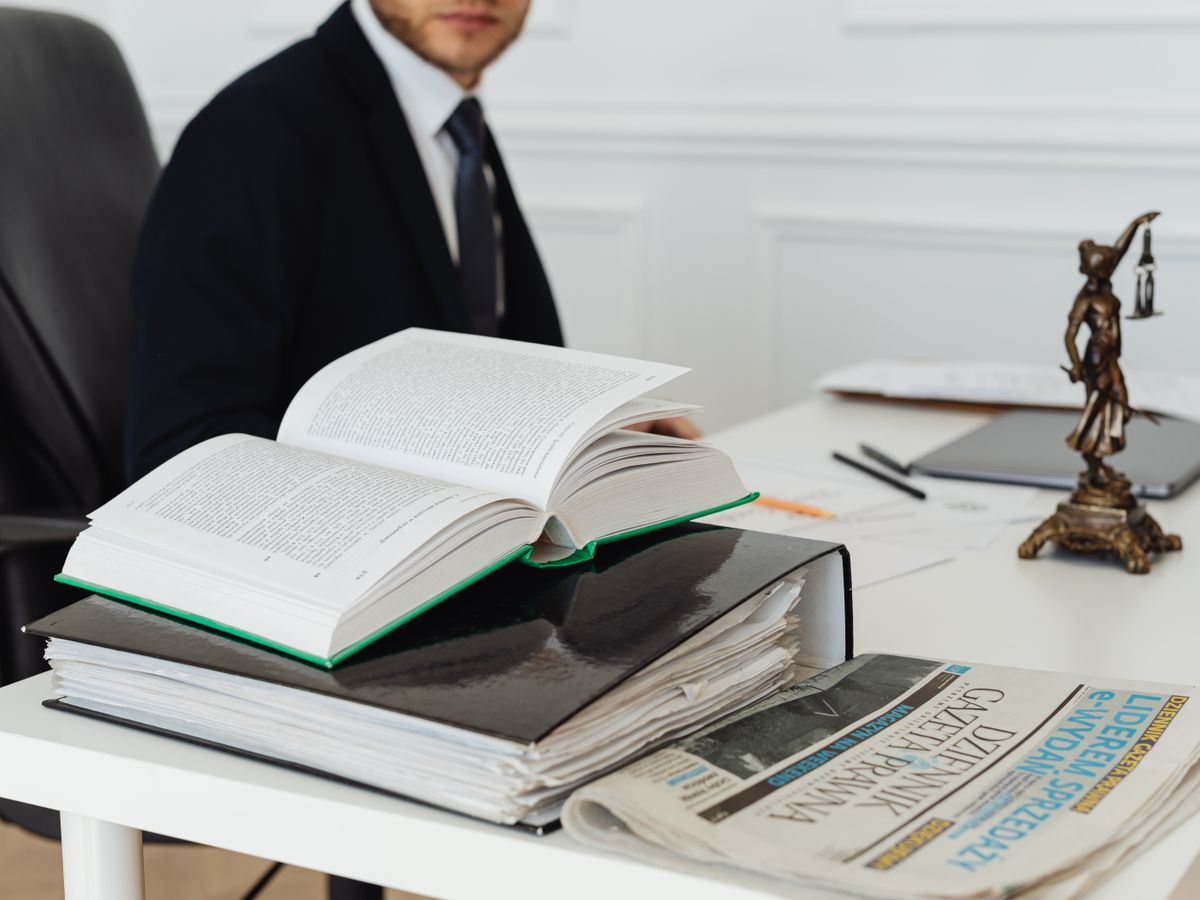 書籍や書類を広げて内容を確認する専門家のデスク